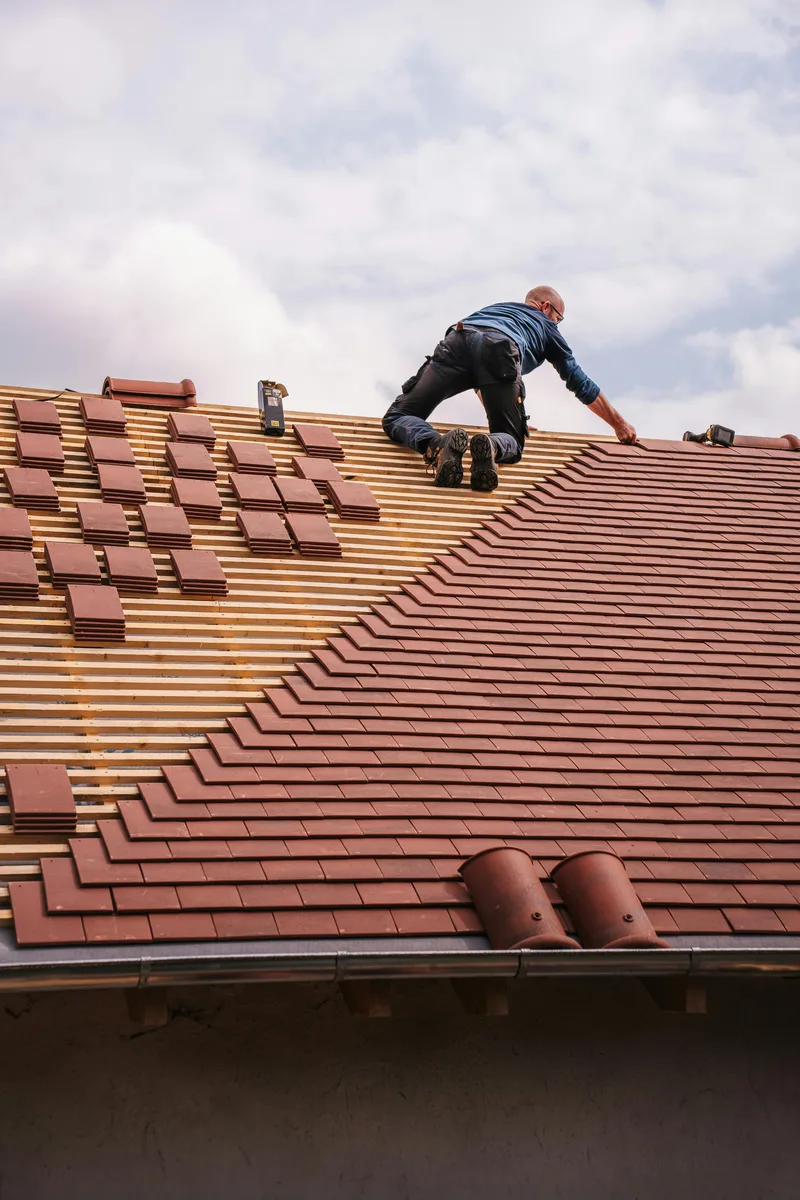 Roofer laying tiles